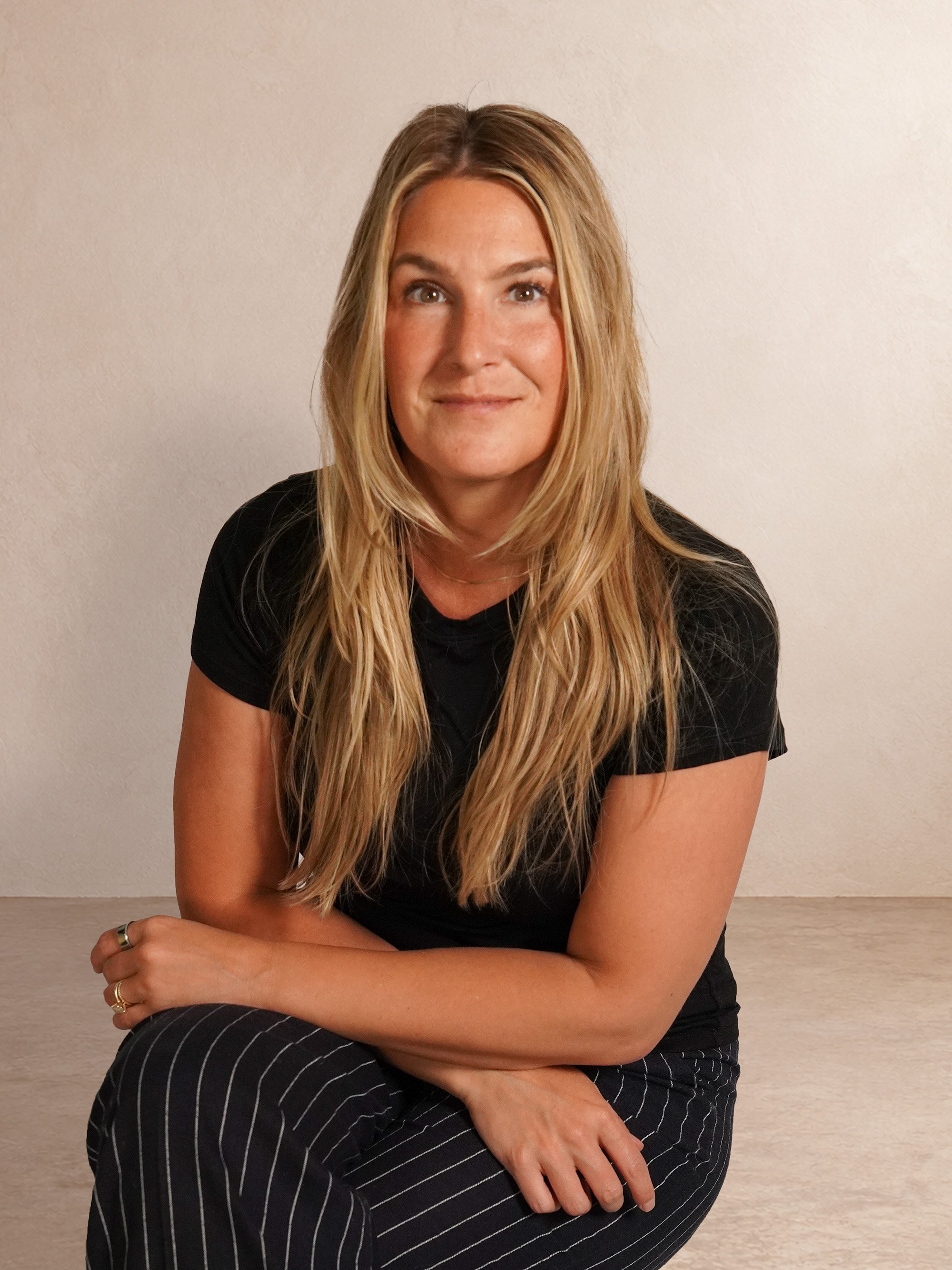 Bonnie seated against a warm ivory studio backdrop