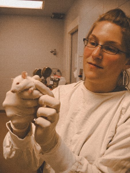 Bonnie in a lab coat holding a laboratory rat